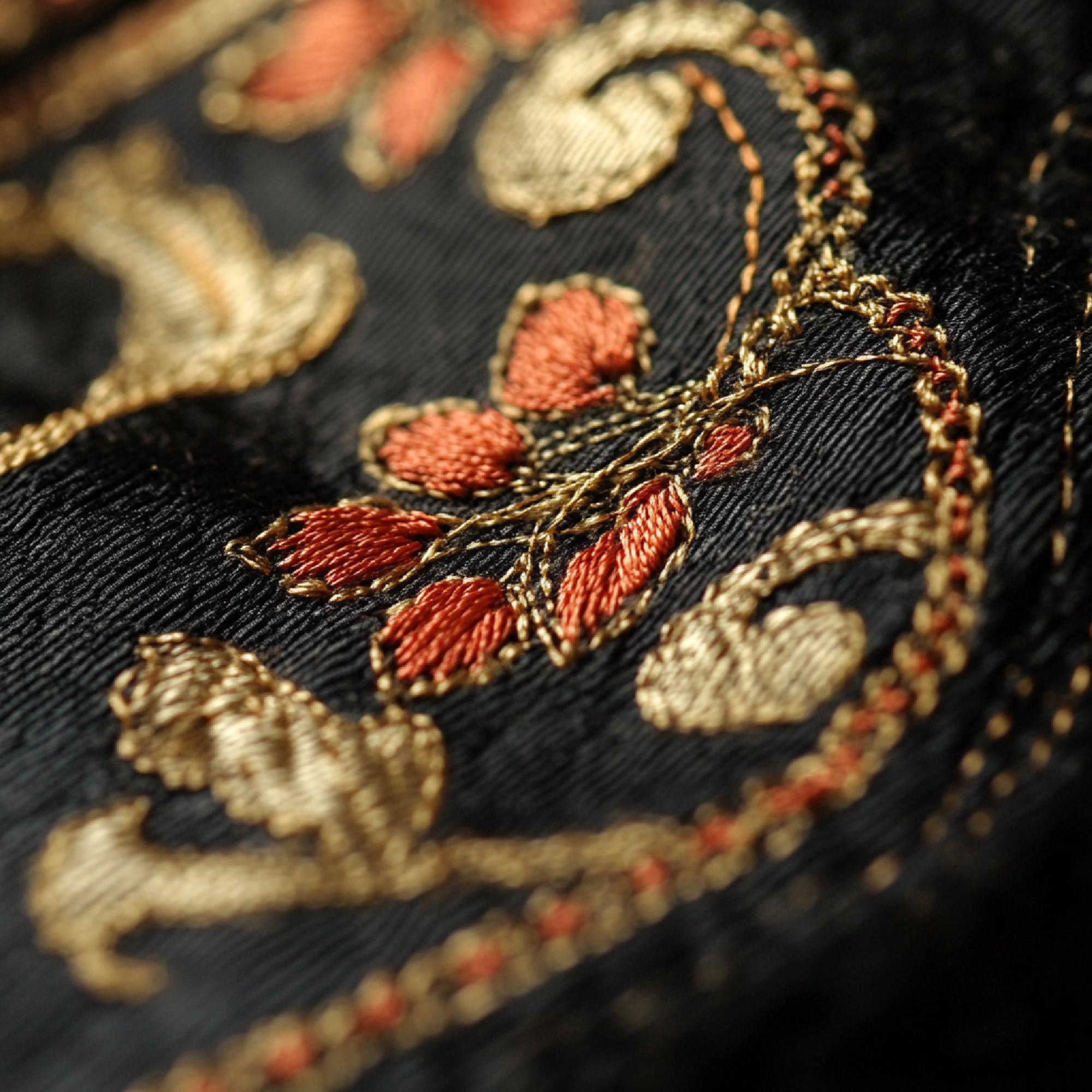 Close-up premium embroidered textile with gold thread